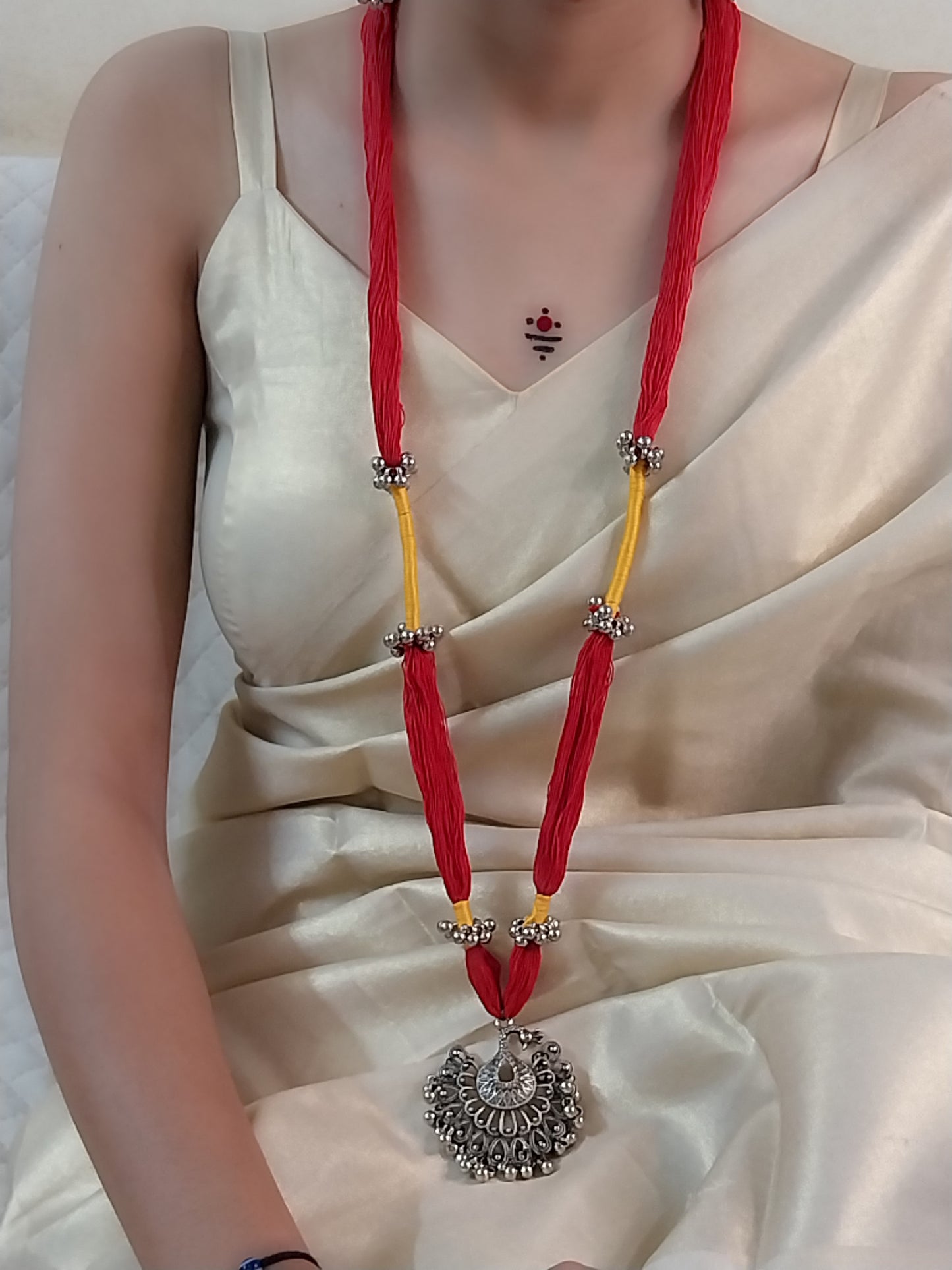 red and yellow cotton thread necklace with oxidized silver pendent