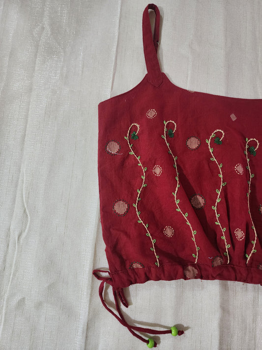 Red embroidered top on a light gray background