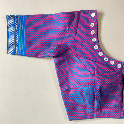 Purple and blue patterned blouse with decorative glasses on a beige background