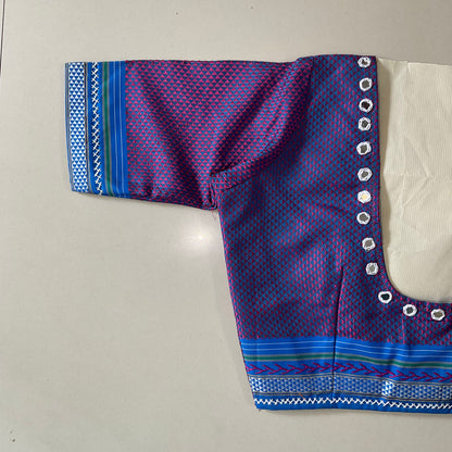 Purple and blue patterned blouse with decorative border on a light gray background