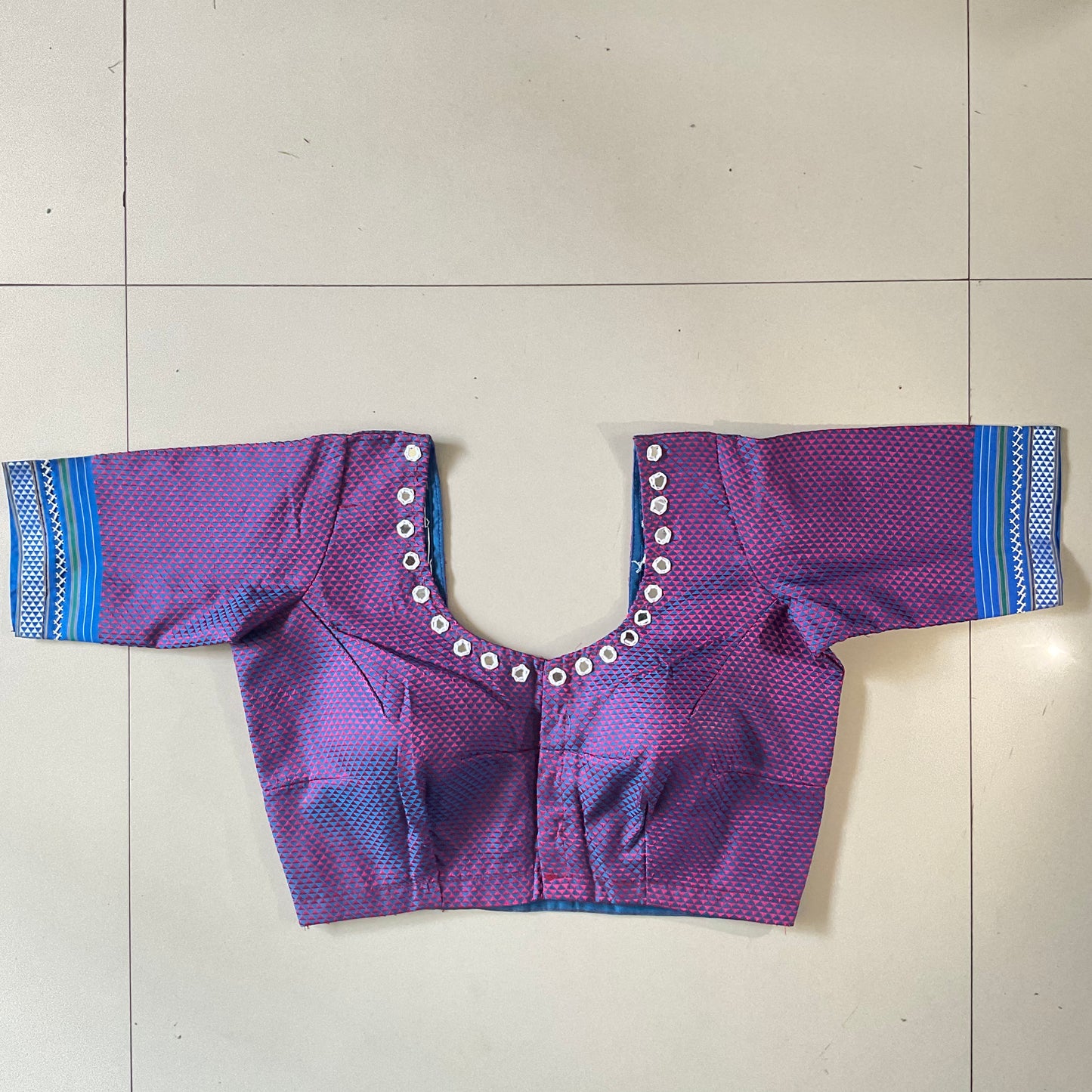 Purple and blue patterned garment on a light gray floor