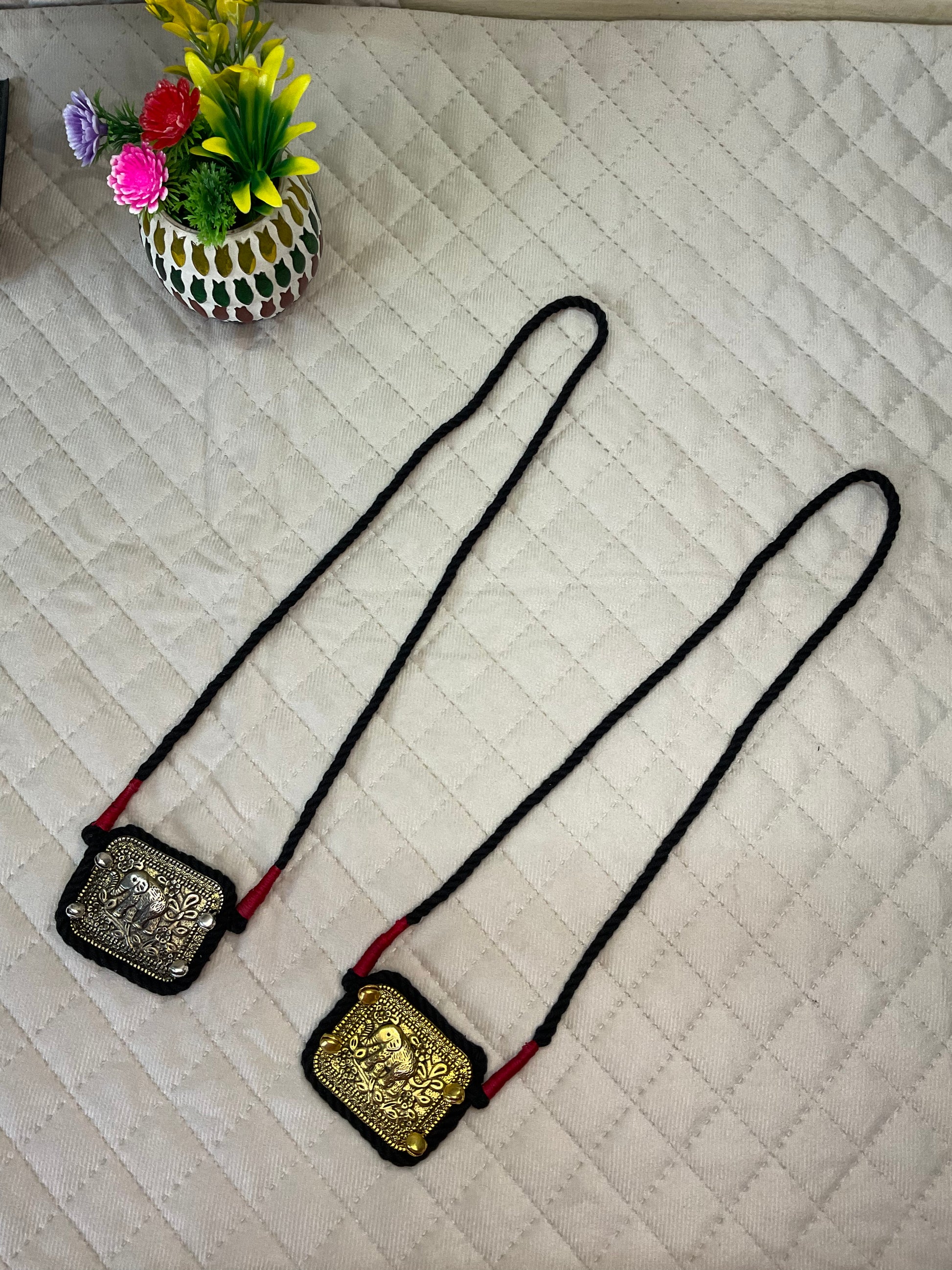two variations of a necklace lay side by side