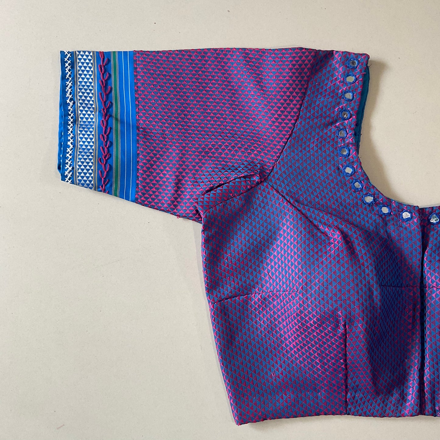 Purple and blue patterned blouse a beige background