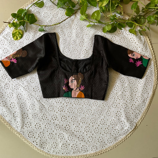 Black blouse with painted designs on a white lace fabric background