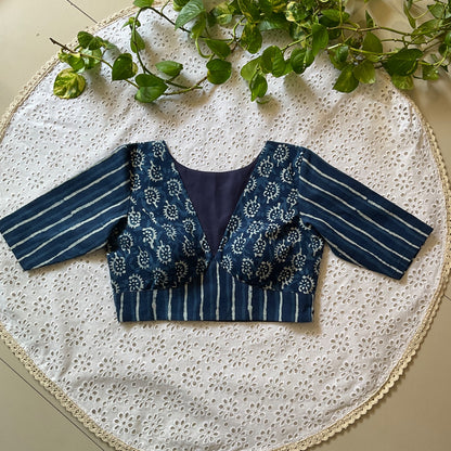 Blue and white patterned blouse on a white lace tablecloth with green leaves.