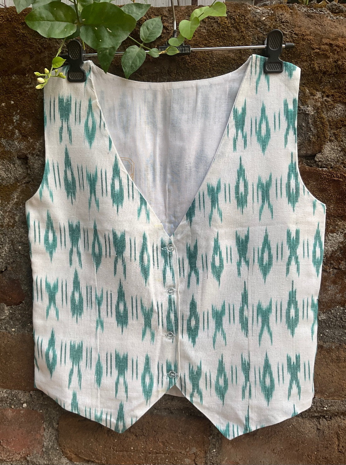 Teal patterned vest on a wooden background