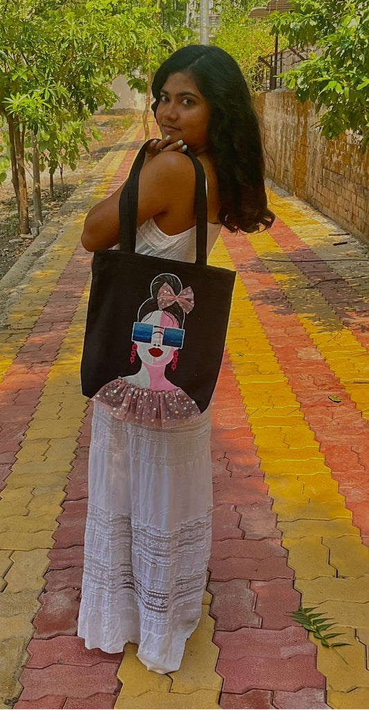 women holding a black tote bag with colorful painting 