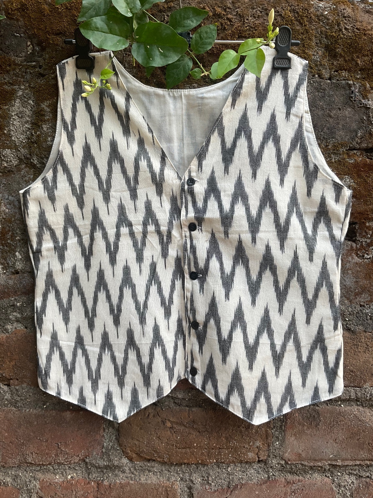 Patterned fabric on a stone surface with green leaves