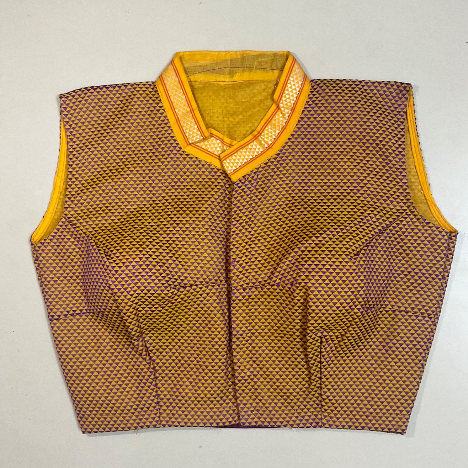 Vest with a geometric pattern and yellow coller on a light grey background