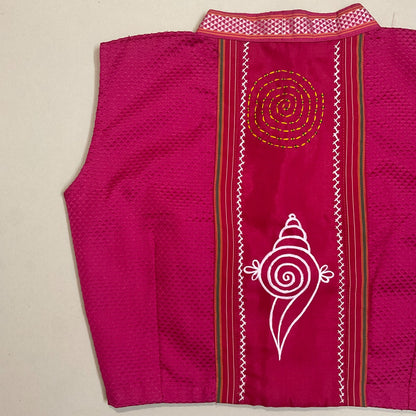 Pink garment with white and gold embroidery on a beige background