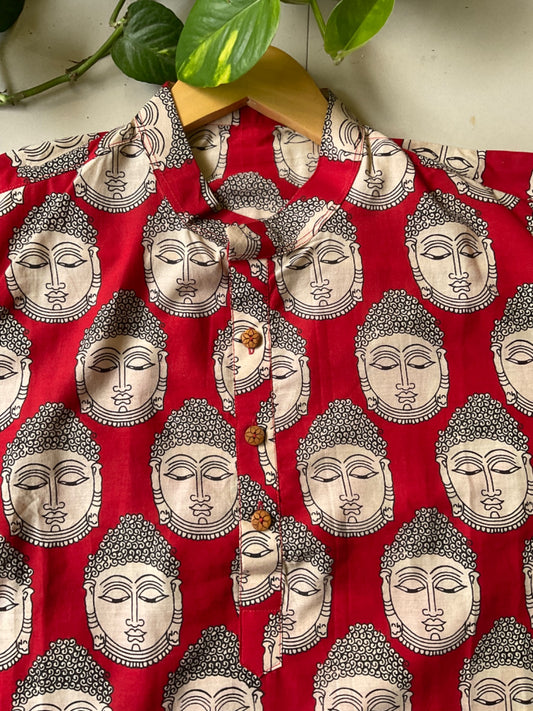 Red kurta with silver Buddha face pattern on a wooden hanger