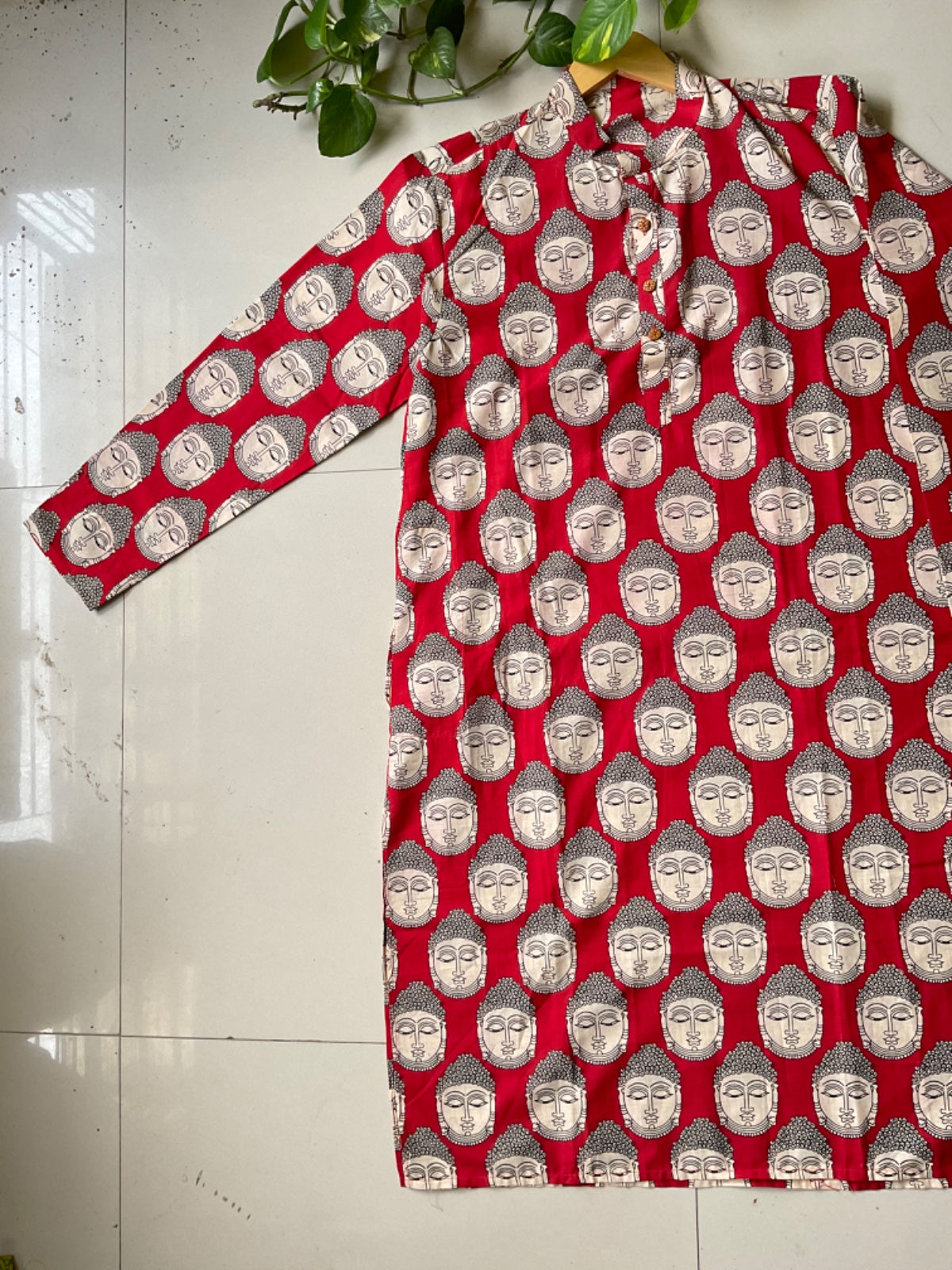Red garment with Buddha pattern on a white floor