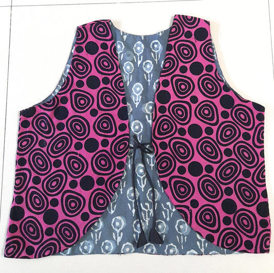 Pink and black patterned vest with gray and white patterned lining on a white background