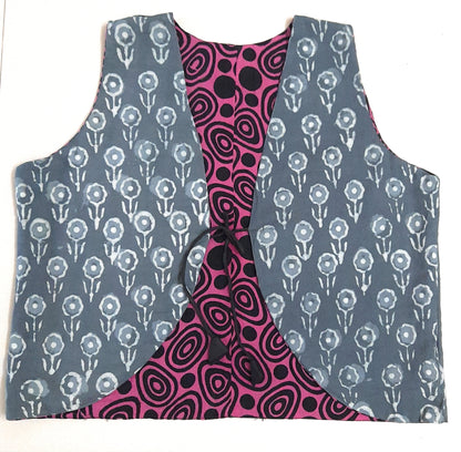 Two-sided patterned vests, one with a grey floral design and the other with a pink and black abstract design, on a white background.