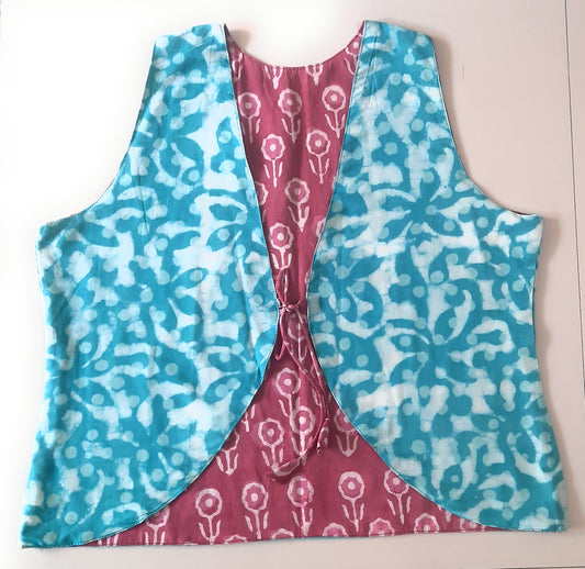 Two-sided sleeveless jacket with blue and pink floral patterns on a white background