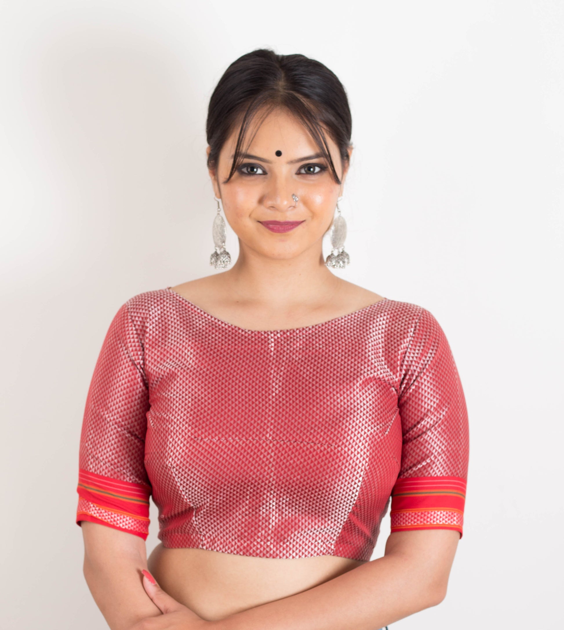 A woman wearing a red blouse with white patterns  on a white background