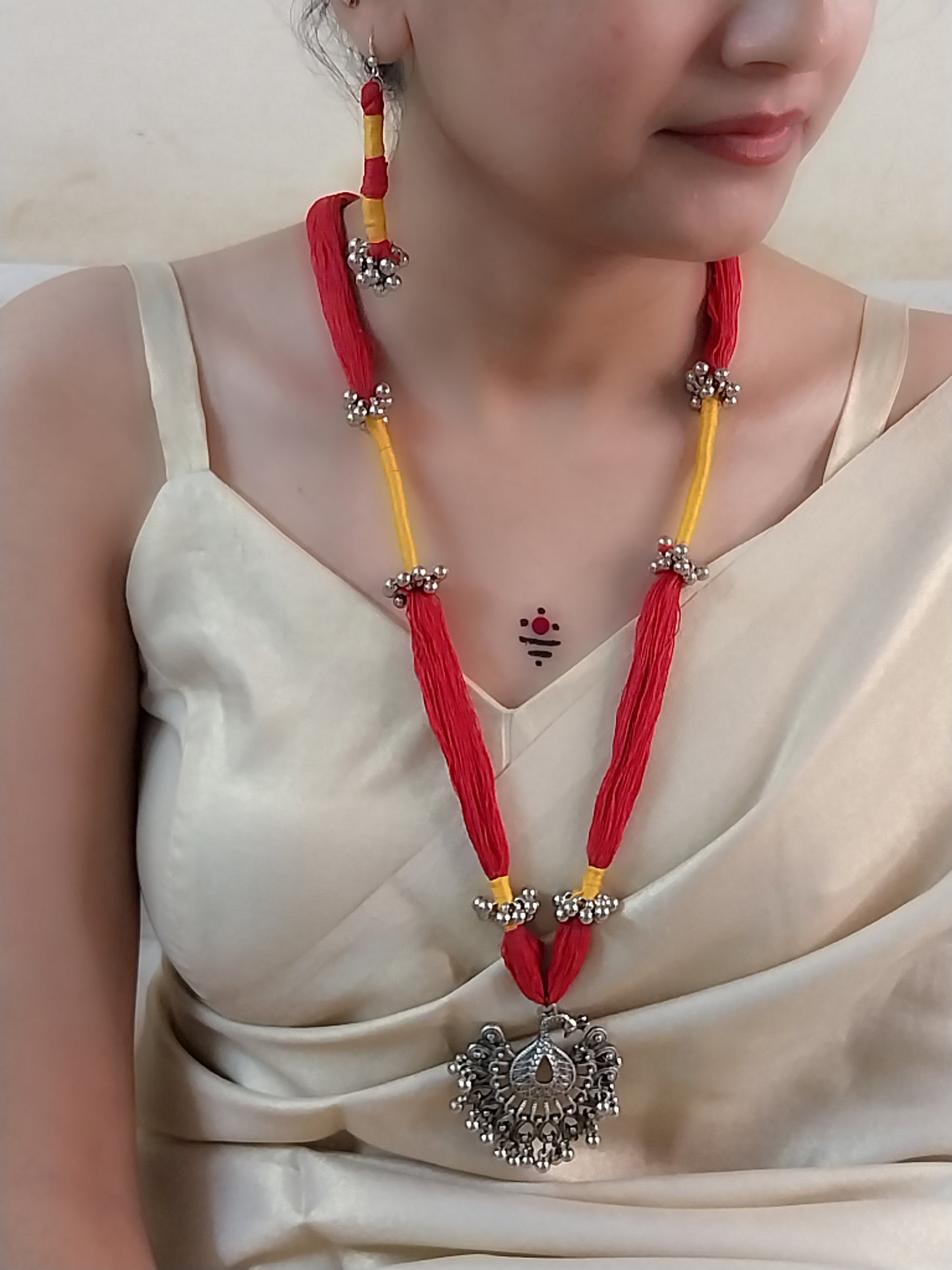 red and yellow cotton thread necklace with oxidized silver pendent